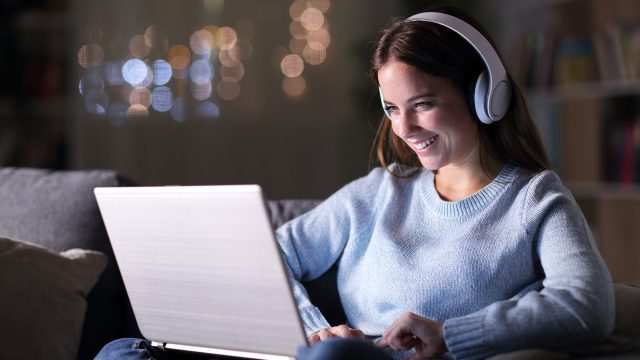 Woman with Headphones on Her Laptop
